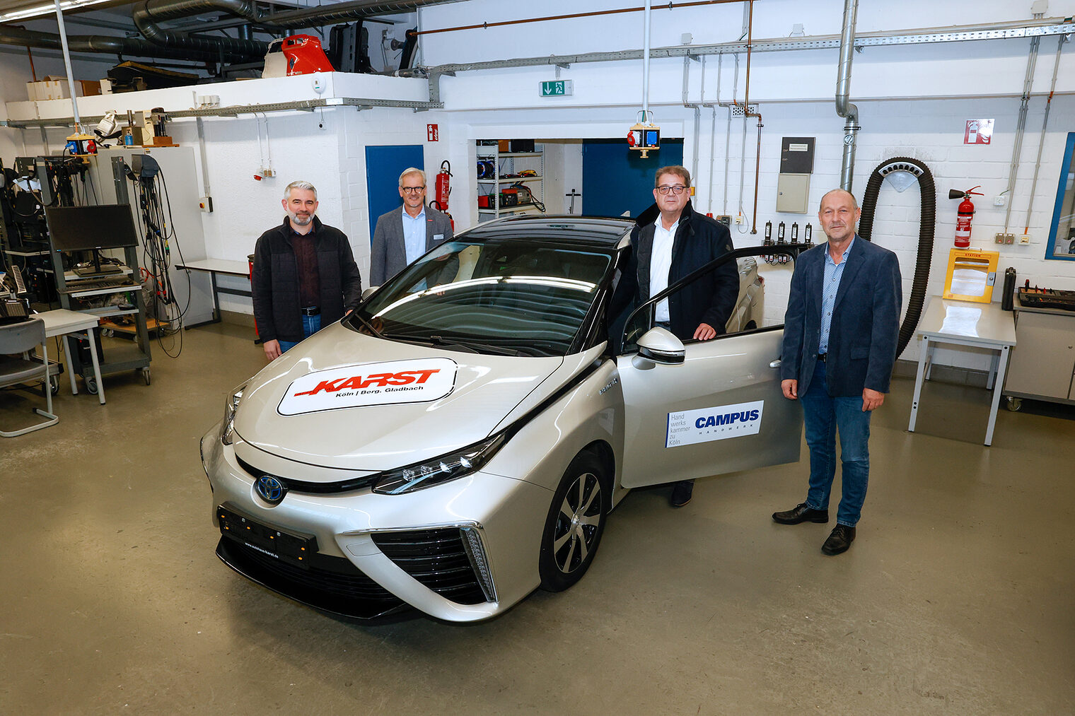 Veli Ayalp, Kfz-Ausbilder am AusbildungsCampus der Handwerkskammer zu Köln, Richard Draga, Stellvertretender Leiter des AusbildungsCampus, Stefan Karst, Geschäftsführer Autohaus Karst GmbH, Michael Schuster, Fachbereichsleiter Kfz am AusbildungsCampus (von links).