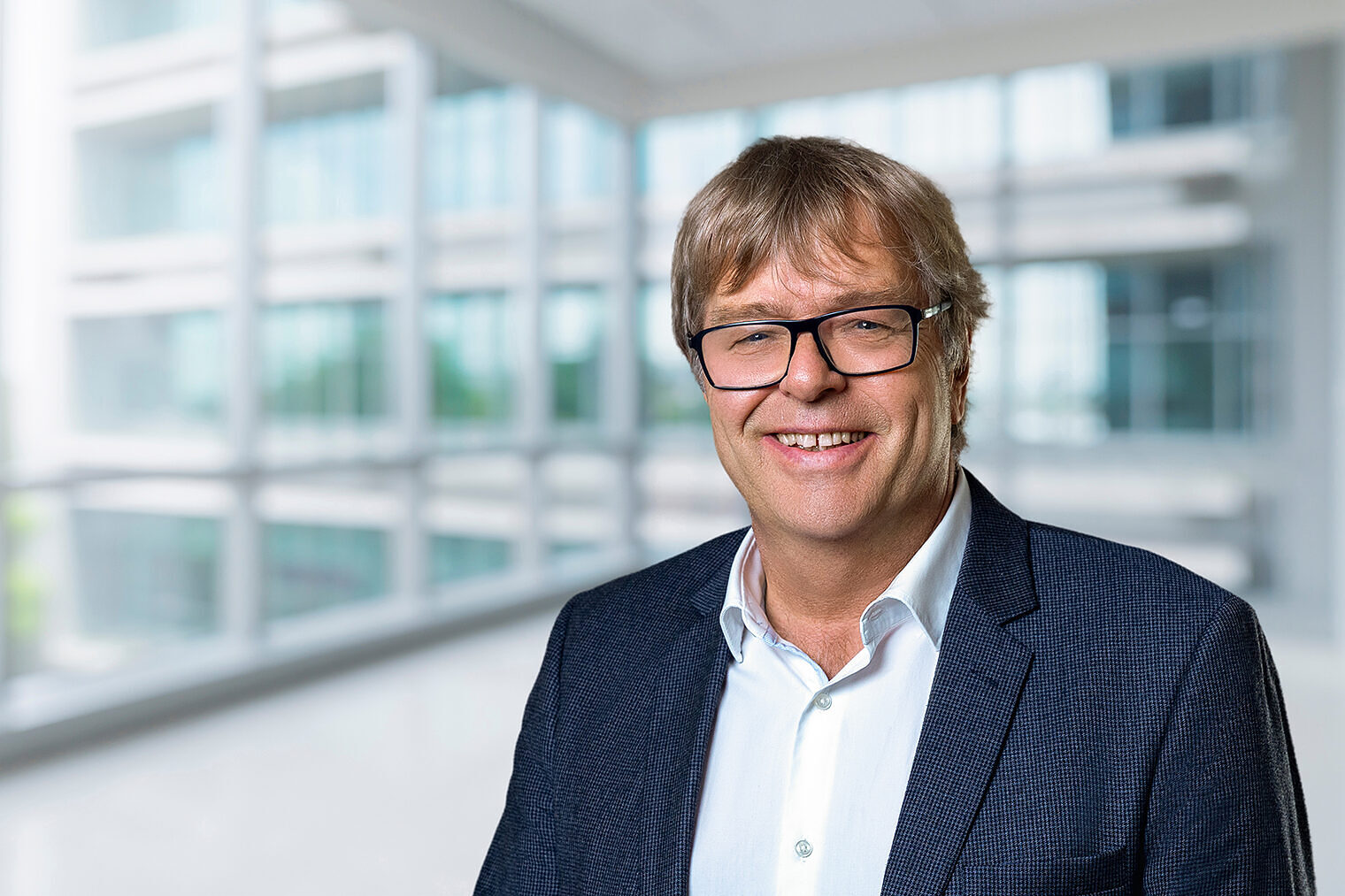  Ein Bild welches den Präsidenten der Handwerkskammer zu Köln, Thomas Radermacher, vor einem dekorativen Hintergrund zeigt.