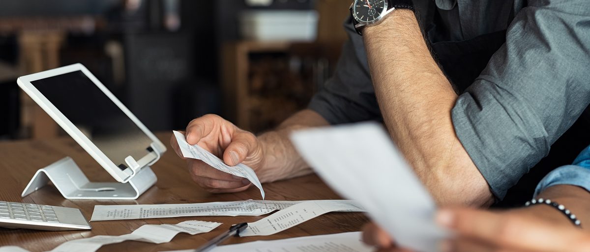 Kassenzettel; Kassenbon; Finanzierung, Kalkulation; finance; calculating; business; bill; hand; management; accounting; billing; calculator; paperwork; investment; planning; accountant; calculation; tax; work; working; owner; small; income; closeup; expenses; financial; checking; profit; holding; invoice; receipt; managing; organize; man; woman; analyze; counting; report; saving; account;