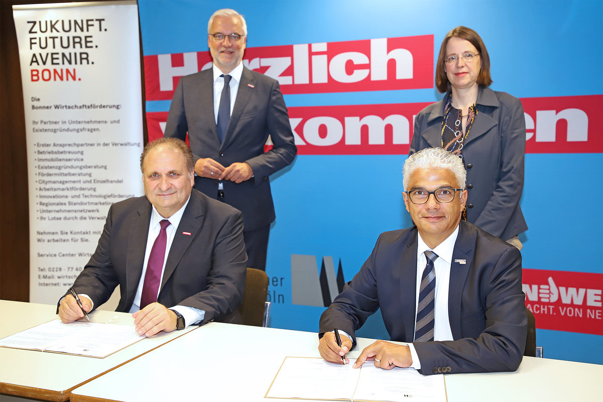 Hans Peter Wollseifer und Ashok Sridharan unterzeichnen gemeinsam mit Garrelt Duin und Victoria Appelbe die Mittelstandsvereinbarung