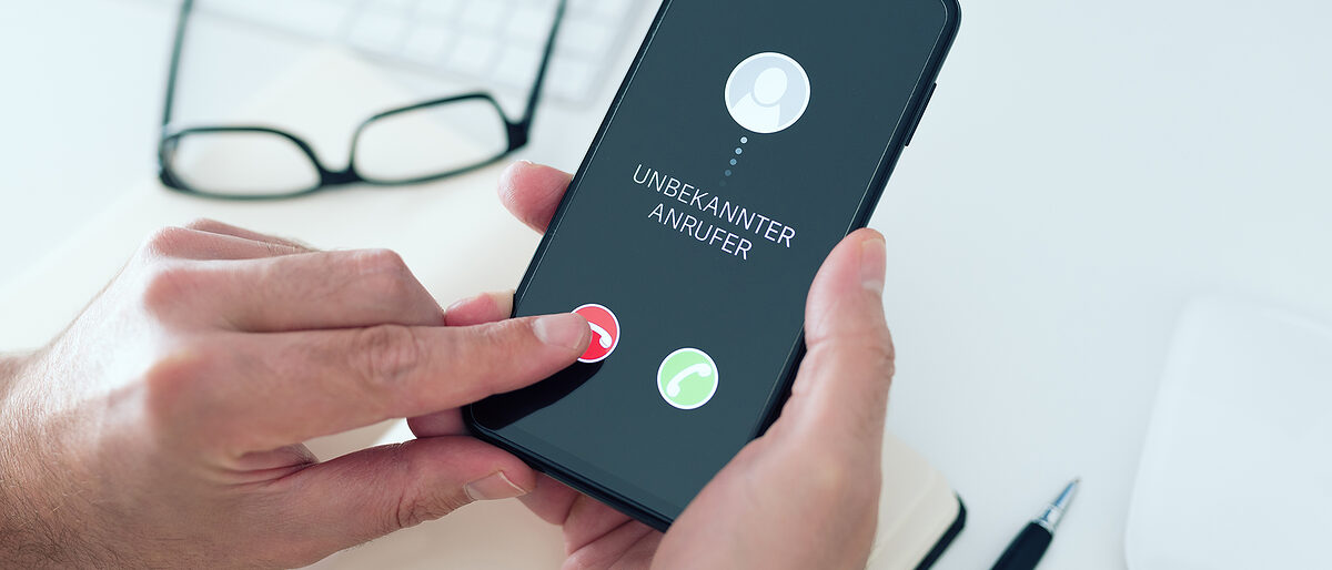 close-up view of person rejecting call from unknown number with text UNBEKANNTER ANRUFER, German for unknown caller, on smartphone, phone scam and phishing concept Schlagwort(e): phone, call, unknown number, unknown caller, rejecting, scam, phishing, smartphone, reject, hang up, german, touch screen, finger, button, annoyance, disturbing, disruption, incoming, incognito, fake, home, mobile phone, screen, stranger, security, concept, suspicious, fraud, answer, cellphone, phone call, ringing, indoors, man, caucasian, lifestyle, unknown, german language, office, desk, communication, holding, phone, call, unknown number, unknown caller, rejecting, scam, phishing, smartphone, reject, hang up, german, touch screen, finger, button, annoyance, disturbing, disruption, incoming, incognito, fake, home, mobile phone, screen, stranger, security, concept, suspicious, fraud, answer, cellphone, phone call, ringing, indoors, man, caucasian, lifestyle, unknown, german language, office, desk, communication, holding