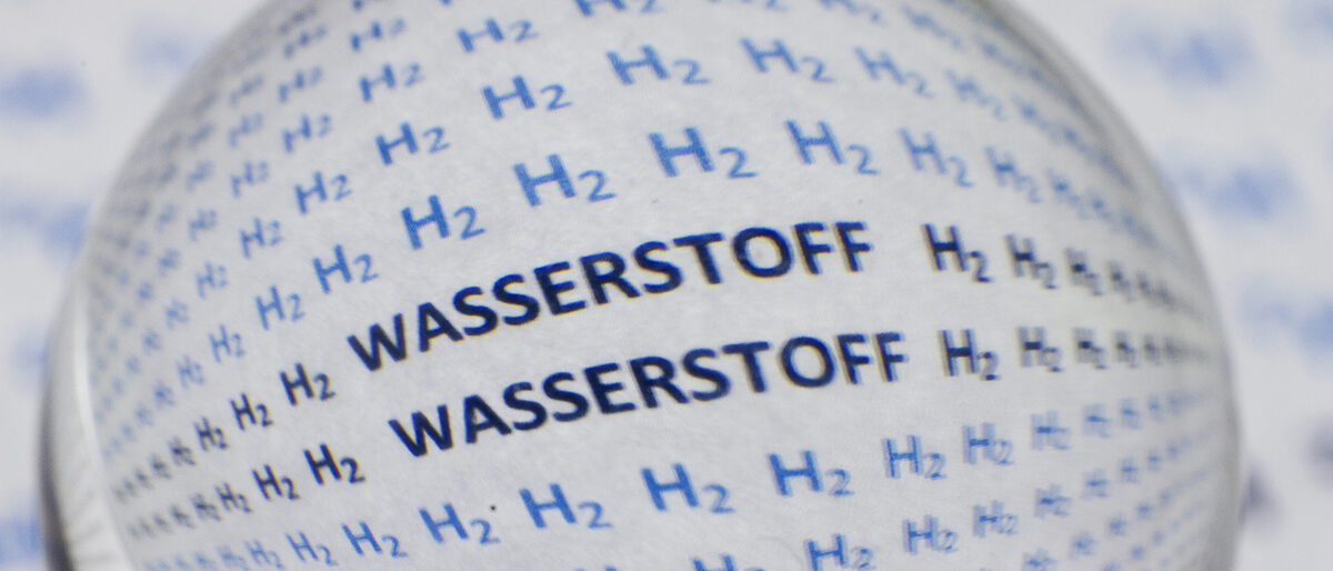 The words H2 and hydrogen in German written on a white surface under a magnifying glass Schlagwort(e): black, discovery, science, molecule, scientific, hydrogen, fuel,, black, discovery, science, molecule, scientific, hydrogen, fuel, physics, recharge, bio, atom, plastic, battery, optic, light, energy, background, spectacle, chemical, tree, african, death, shower, blue, man, element, torus, electron, metal, atomic, glasses, plant, sphere, fluid, research, fortune, study, symbol, space, conservation, magnifying, glass
