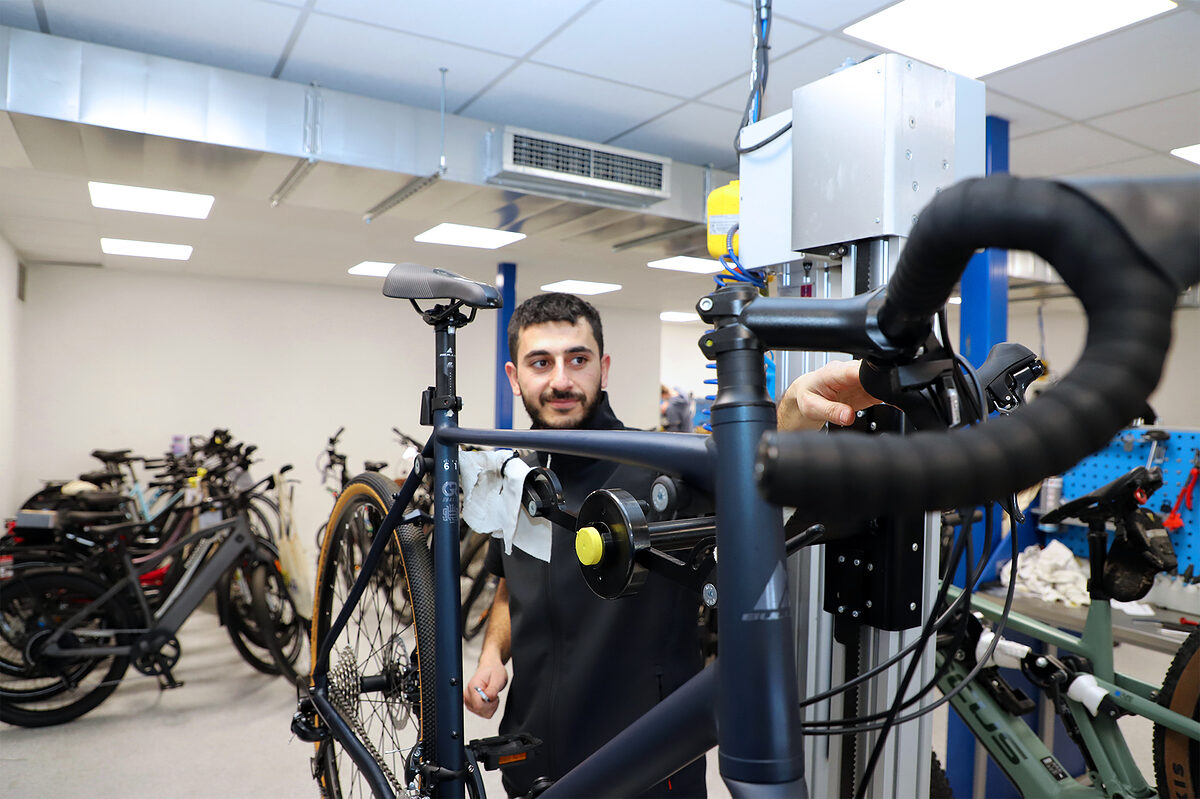 Azubi Sezar führt Wartungsarbeiten an einem Rennrad durch