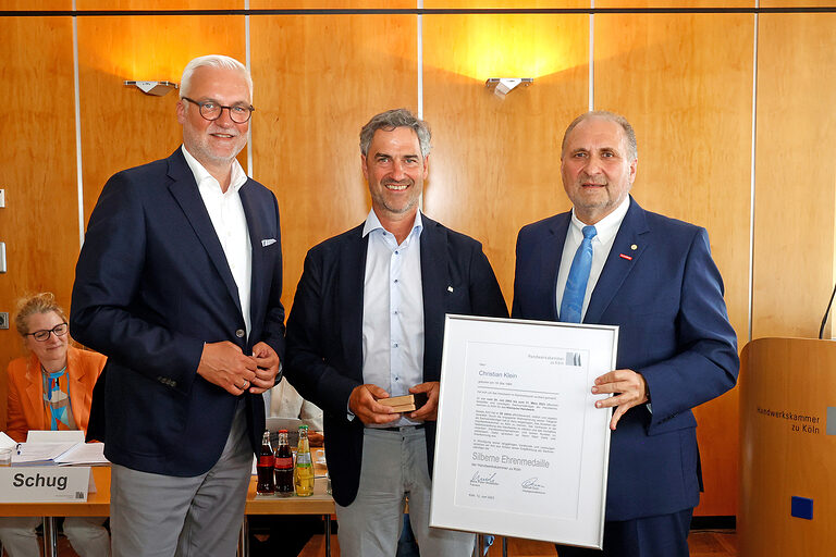 Garrelt Duin (l.), Hauptgeschäftsführer Handwerkskammer zu Köln, und deren Präsident Hans Peter Wollseifer (r.) ehren den ehemaligen Sachverständigen Christian Klein.